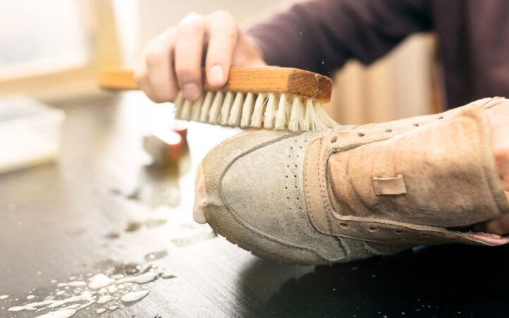 Cleaning suede sneakers with a soft-bristle brush